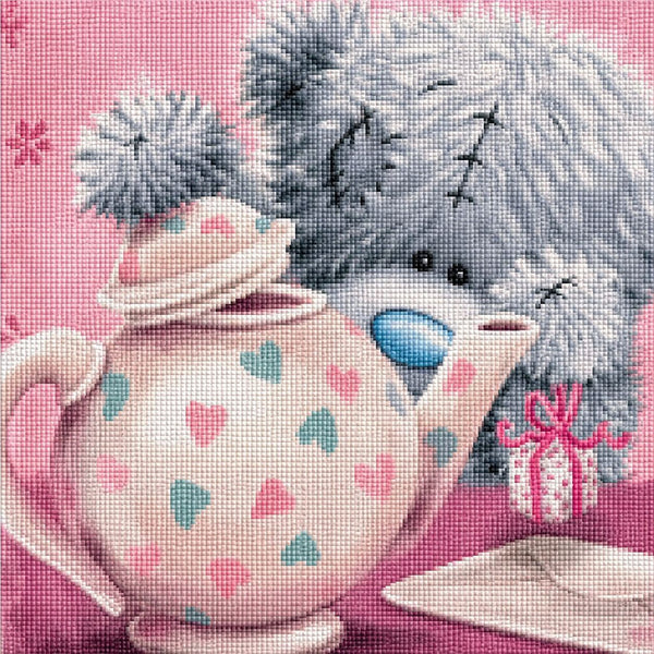 Diamond Painting mit grauem Teddy hinter einer Teekanne mit Herzmuster und kleinem Geschenk. Mockup.