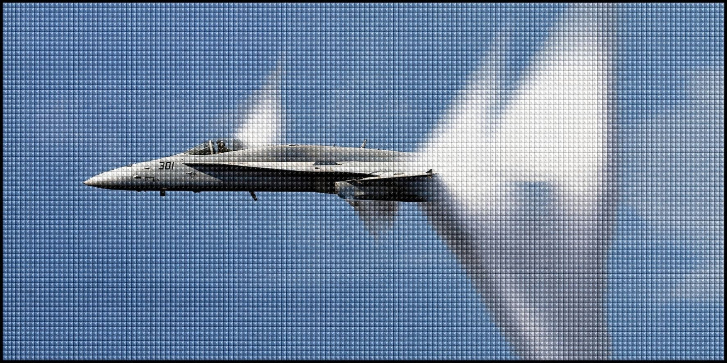 Diamond Painting eines grauen Kampfjets im Flug mit großer Kondensationswolke vor blauem Himmel. Mockup.