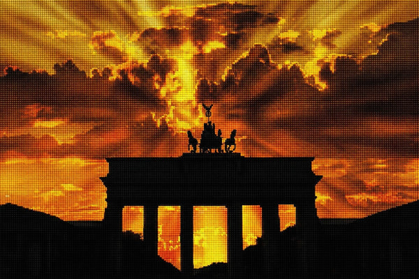 Diamond Painting mit Brandenburger Tor als Silhouette vor goldenem Sonnenuntergang und dramatischen Wolken. Mockup.
