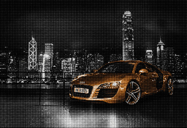 Diamond Painting eines goldenen Audi R8 vor einer beleuchteten Stadt-Skyline bei Nacht. Mockup.