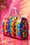 Diamond Painting mit bunter Handtasche, farbigen Streifen, Knöpfen und Symbolen vor pinkem Hintergrund