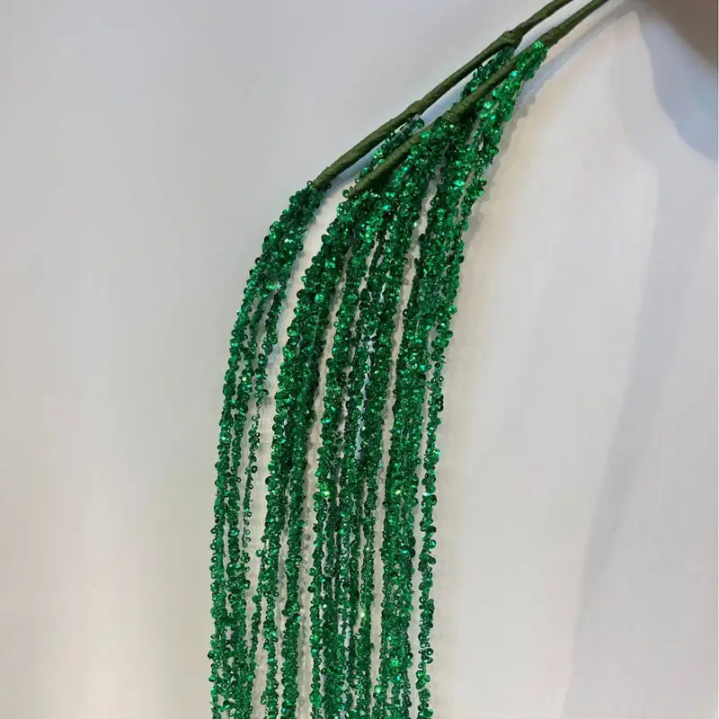 Gruene Glitzer Deko-Zweige mit langen geschwungenen Haengern als dekorativer Schmuck fuer Weihnachten