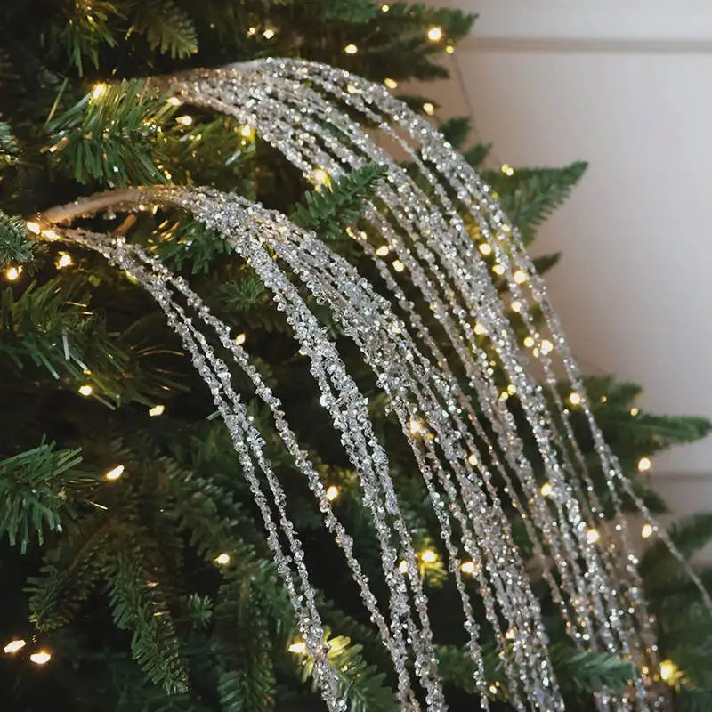 Silberne Glitzer Deko-Zweige mit langen herabhaengenden Elementen als festliche Weihnachtsbaum Dekoration