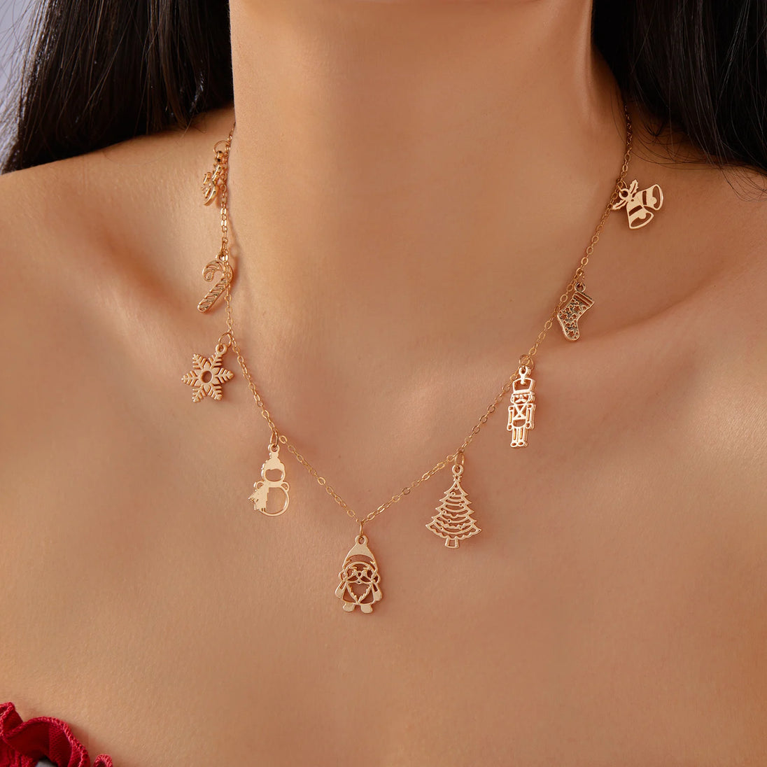 Goldfarbene Charm-Halskette mit verschiedenen eleganten Weihnachtsanhängern und festlichen Motiven