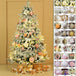 Kuenstlicher Weihnachtsbaum mit LED-Beleuchtung, rosa und goldenem Baumschmuck sowie dekorativen Geschenkpaketen