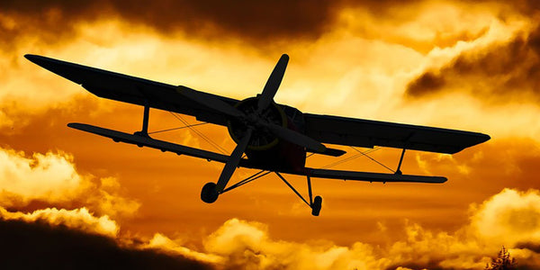 Diamond Painting mit Doppeldecker als Silhouette vor goldorange leuchtendem Wolkenhimmel.