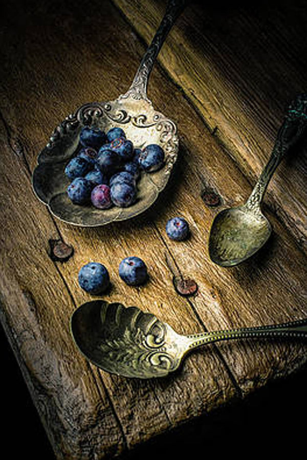 Diamond Painting mit Blaubeeren in einer Metallschale und Vintage-Löffeln auf einem Holztisch.