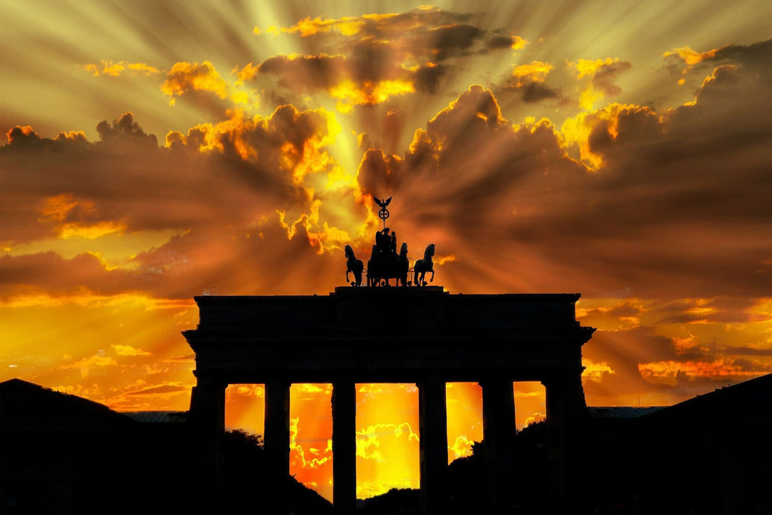 Diamond Painting mit Brandenburger Tor als Silhouette vor goldenem Sonnenuntergang und dramatischen Wolken.
