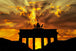 Diamond Painting mit Brandenburger Tor als Silhouette vor goldenem Sonnenuntergang und dramatischen Wolken.

