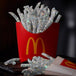 Diamond Painting einer roten Pommes-Schachtel mit silber glitzernden Pommes frites aus Diamanten.