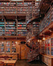 Diamond Painting einer antiken Bibliothek mit Wendeltreppe, vielen Bücherregalen und Holztischen.
