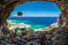 Diamond Painting vom Ausblick aus einer dunklen Steinhöhle auf eine türkisfarbene Meeresbucht mit hellem Sandstrand.