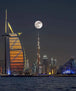 Diamond Painting der Skyline von Dubai mit Burj Khalifa und Burj Al Arab unter einem großen Vollmond. 
