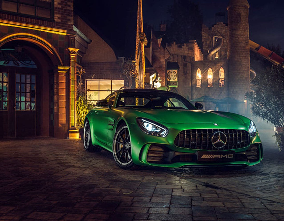 Diamond Painting eines grünen Mercedes-AMG Sportwagens vor einem beleuchteten historischen Gebäude bei Nacht. 