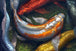 Diamond Painting von mehreren Koi-Fischen in Rot, Gold und Silber, die in dunklem Wasser schwimmen.