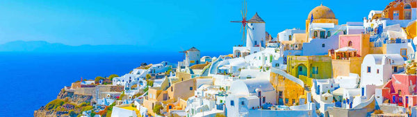 Diamond Painting Panorama der weißen Häuser von Santorini mit blauen Kuppeln am Meer unter blauem Himmel.
